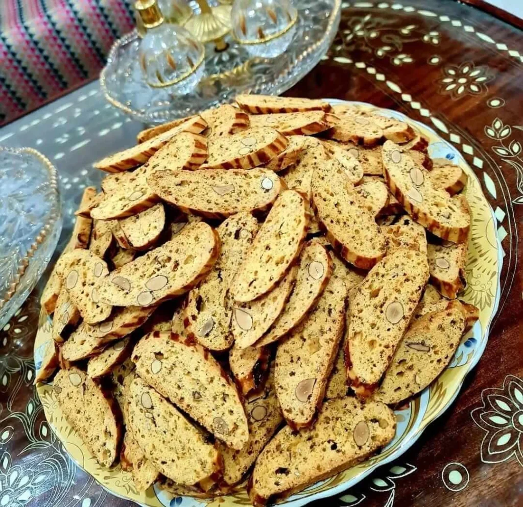 Moroccan Fekkas cookies with almonds and raisins on a decorative plate.