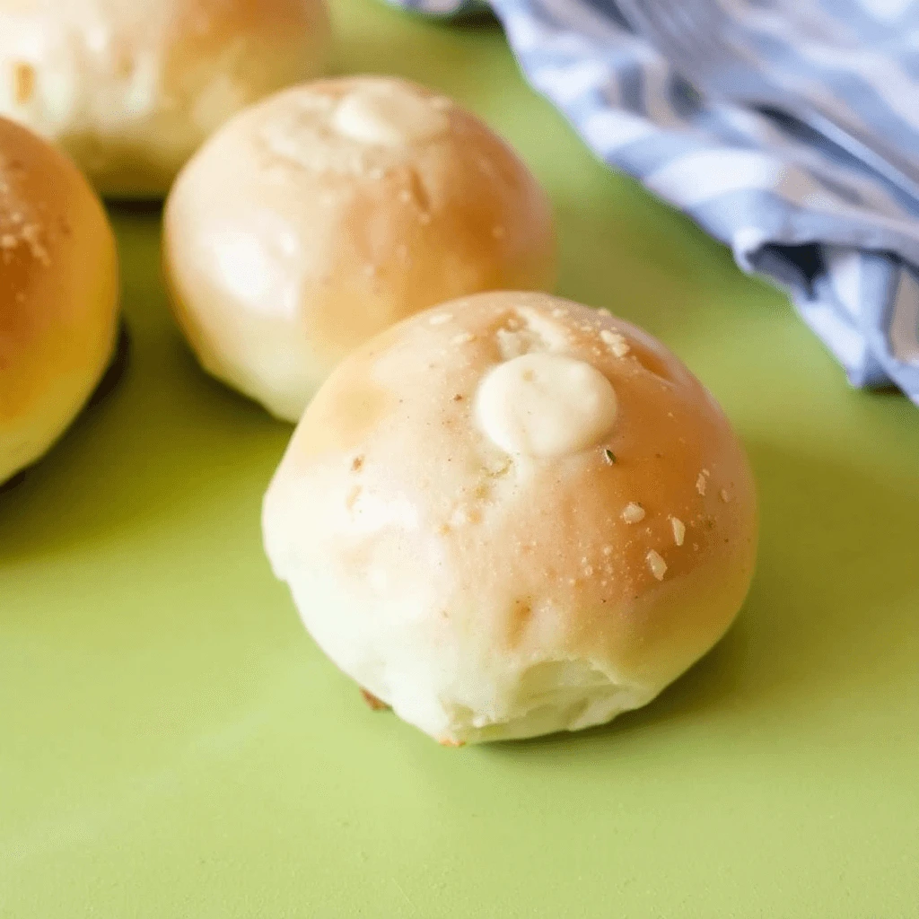 Golden brown dinner rolls without yeast, freshly baked and displayed on a rustic wooden table.