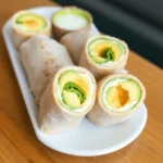 Close-up of homemade avocado egg rolls inspired by Cheesecake Factory, served on a white plate with dipping sauce.